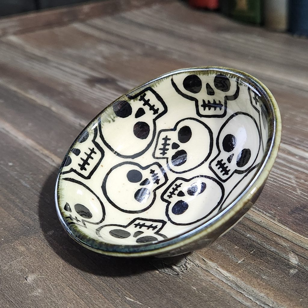 black and white handpainted skulls on a tiny dish
